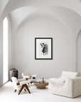 ‘[Rose Mallow’ – a black and white art print presented in a black frame, shown in a minimalist living room.