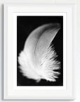 Black and white art print of a baby feather titled ‘Guardian Feather’, presented in a white frame.
