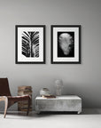 Two black and white art prints, including ‘Serenity’ and 'Harmony Feather', presented in black frames, shown on a study wall.