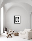‘Lucky Feather' – black and white art print presented in a black frame, shown in a minimalist living room.