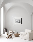 ‘Snail Shell’ – black and white art print presented in a black frame, shown in a minimalist living room.