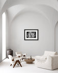 Black & white framed print of dandelions mid flight hanging in a contemporary living room.