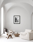 Black and white photograph of a Dendrobium Orchid flower hanging on a wall in an all-white living room.